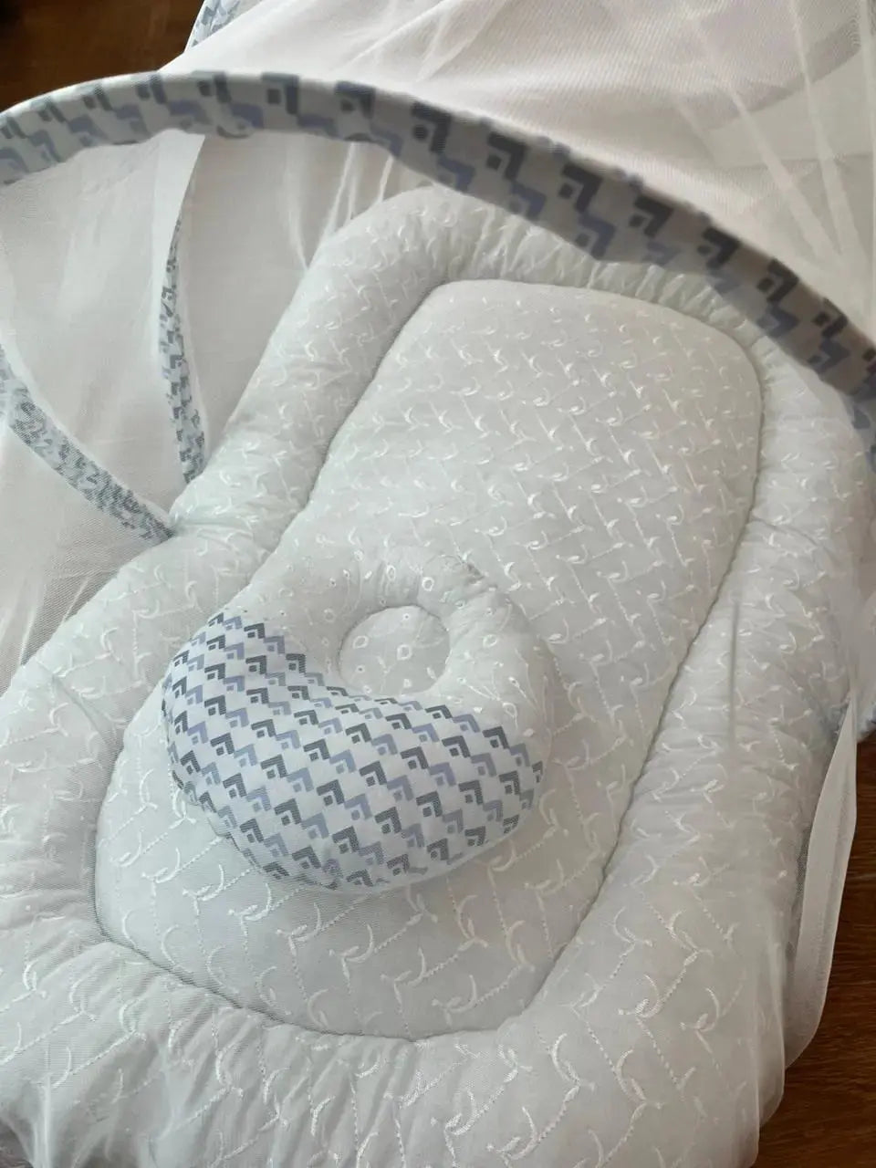Soft white baby nest with patterned pillow and mesh canopy, Little Flower collection