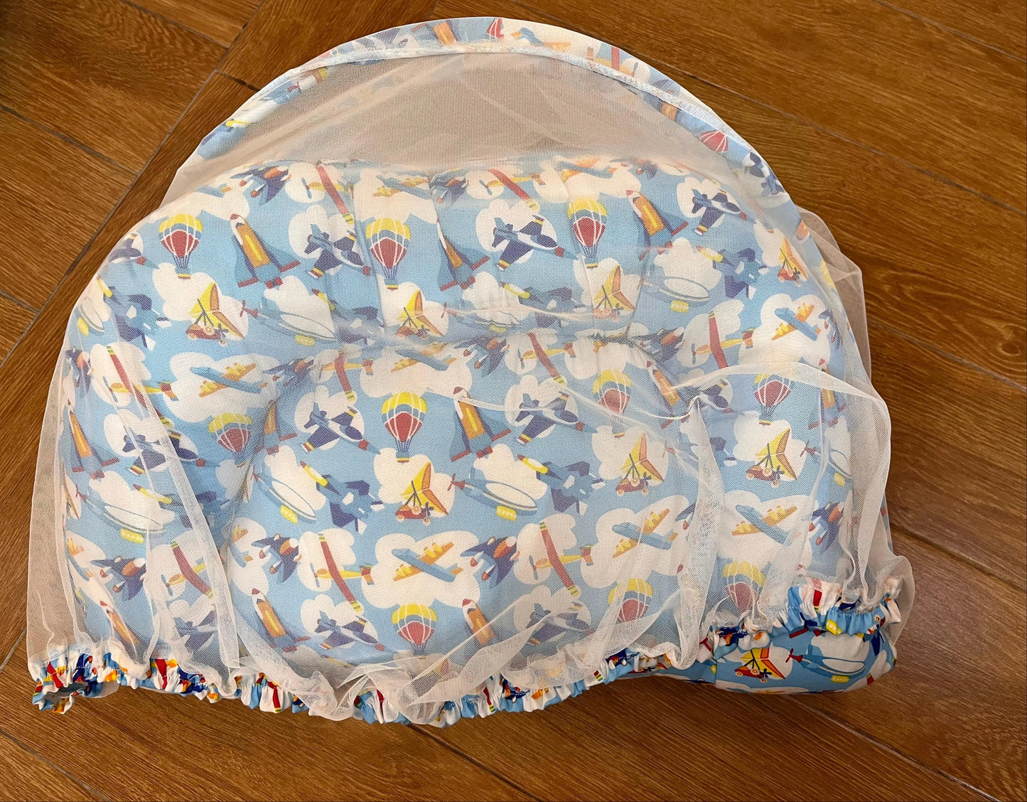 Baby bouncer with cartoon character pattern on a wooden floor
