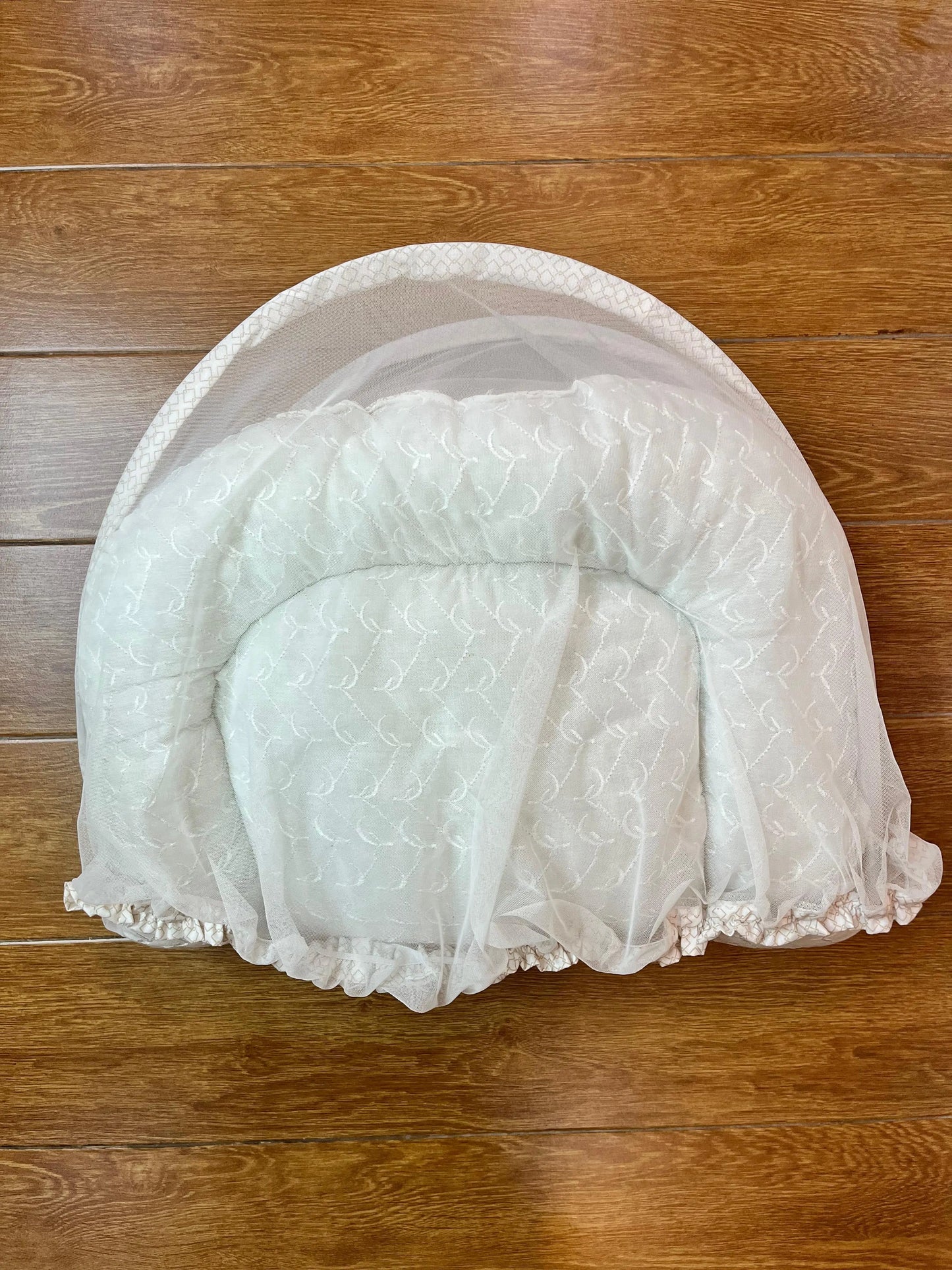 White pet bed on a wooden floor