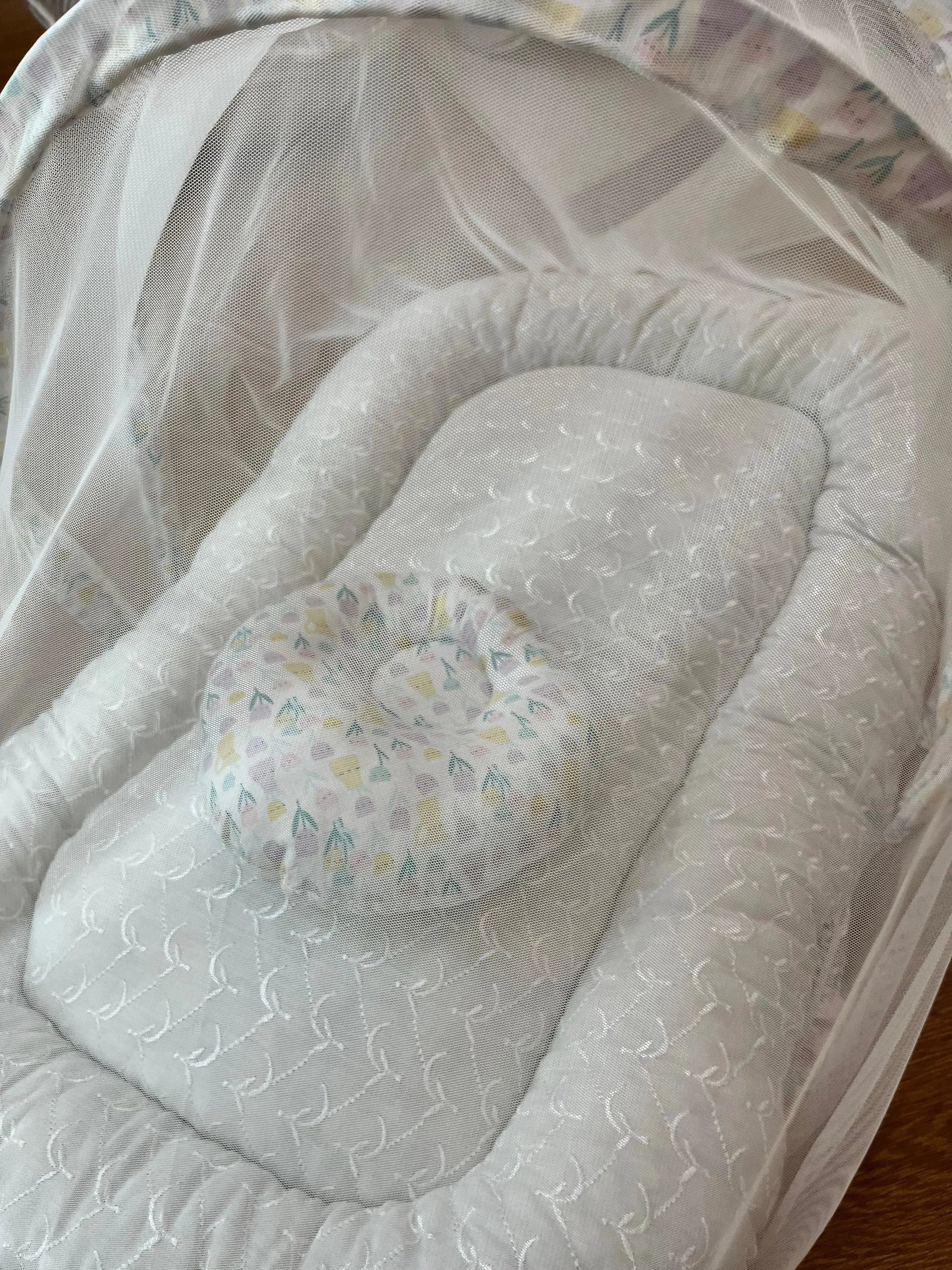 Soft white baby bassinet with patterned pillow and mesh canopy, Little Flower